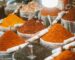 A lively spice market scene showcasing an array of colorful powders and spices in variety.