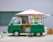 Colorful green food truck with umbrella, offering street food in Tokushima, Japan.