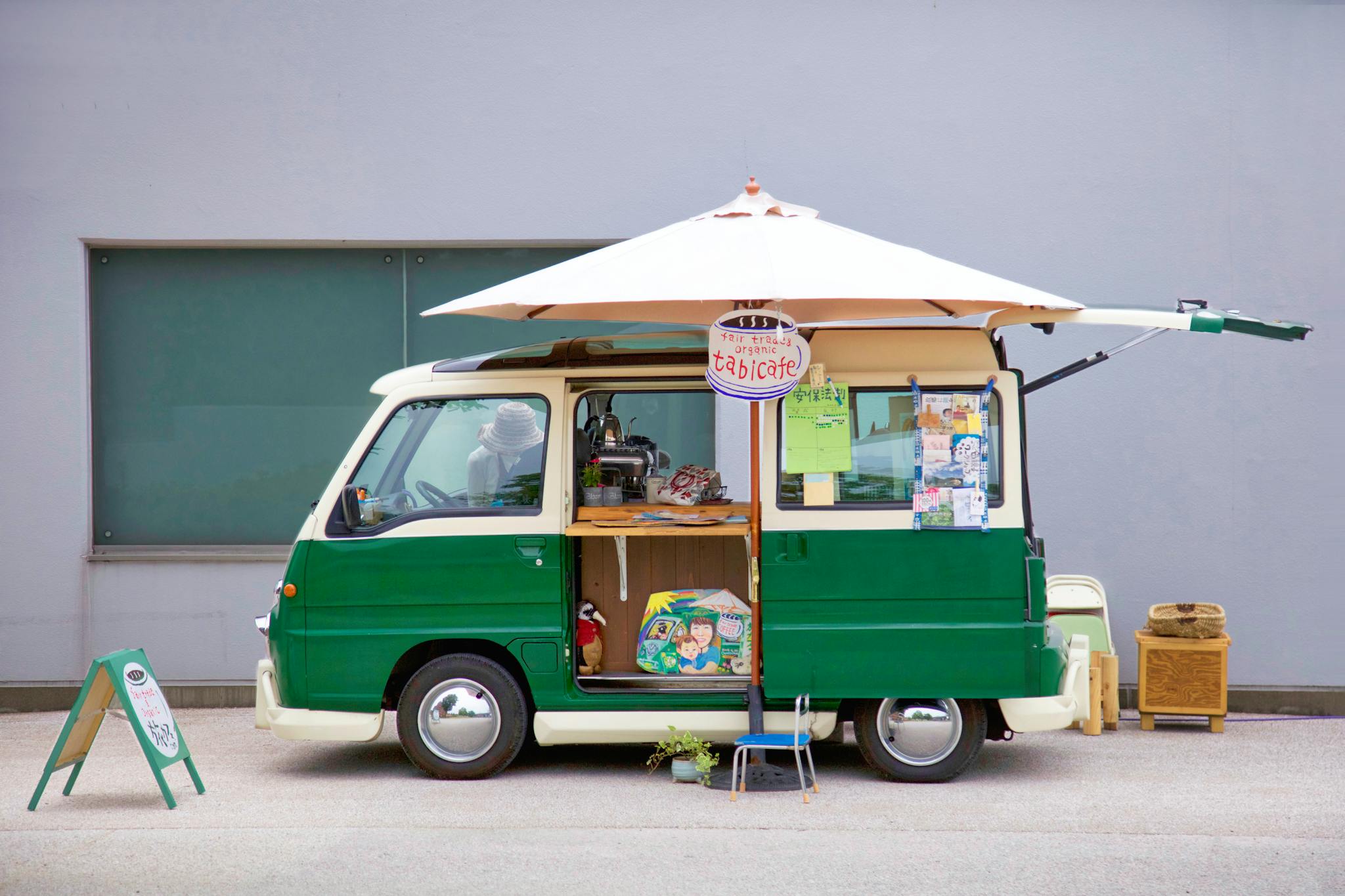 Colorful green food truck with umbrella, offering street food in Tokushima, Japan.