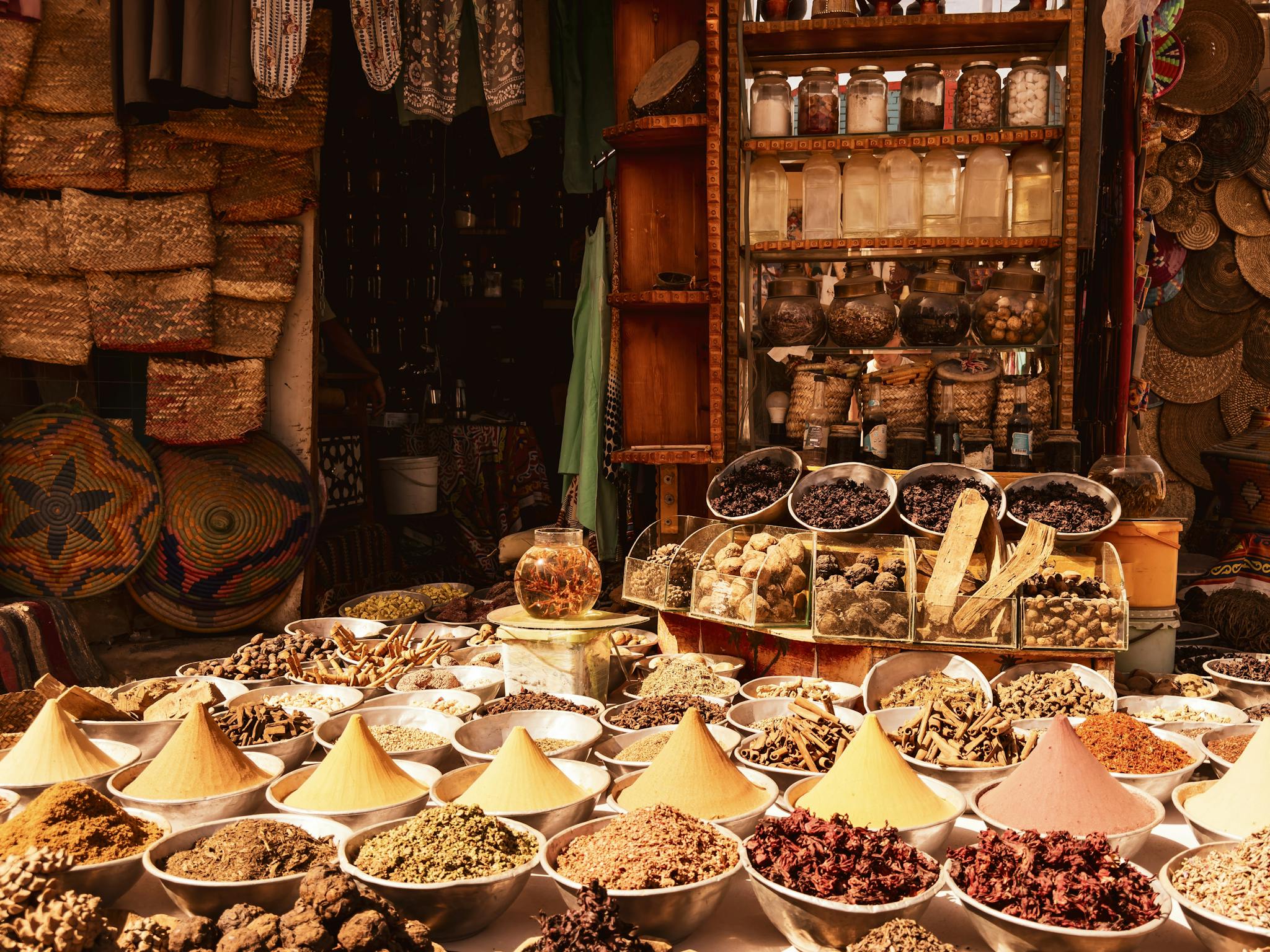 Colorful spices and herbs on display in a traditional outdoor market, showcasing cultural richness and diversity.
